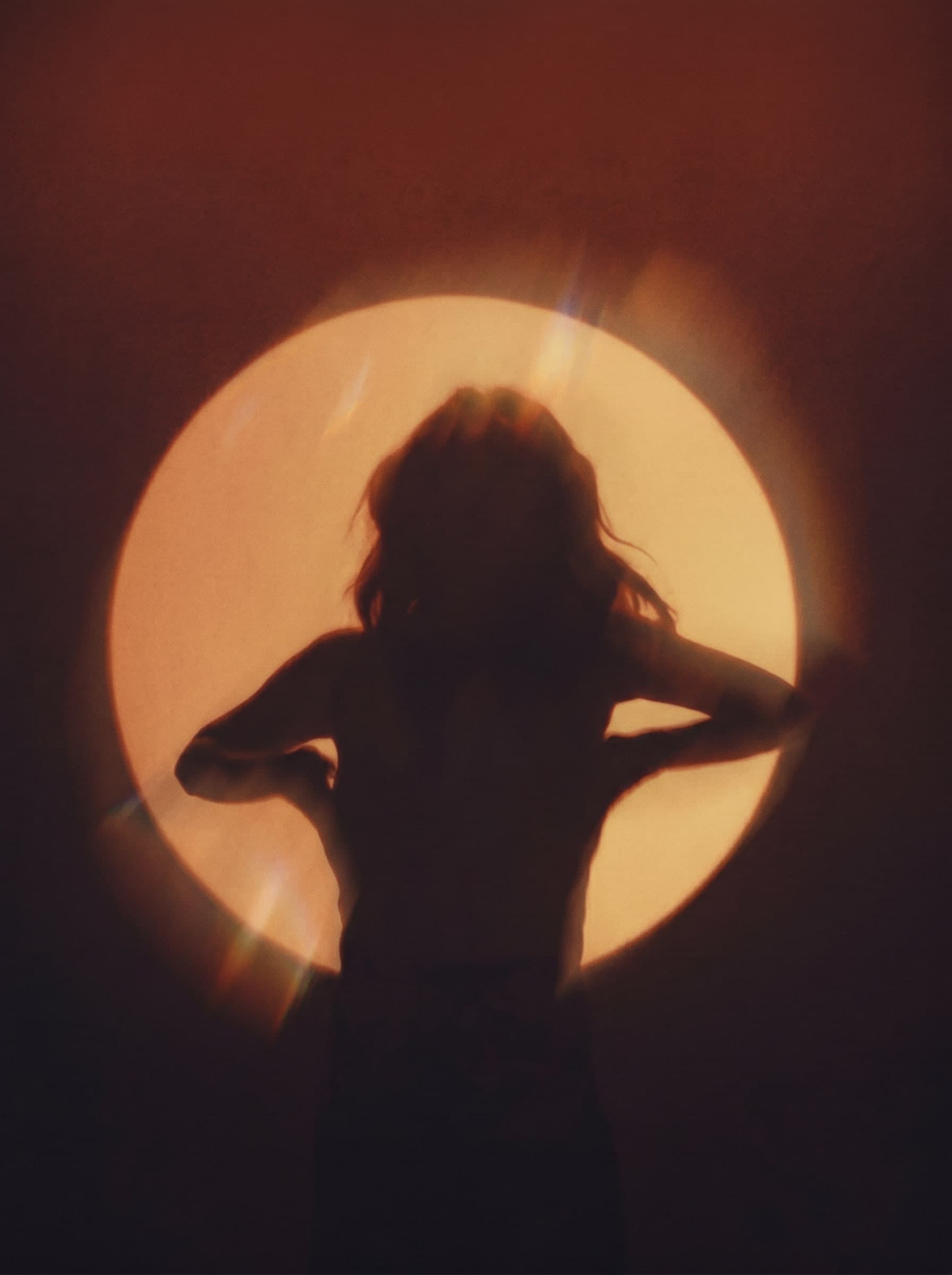 A silhouette glowing before a full moon — the GLAZE mood