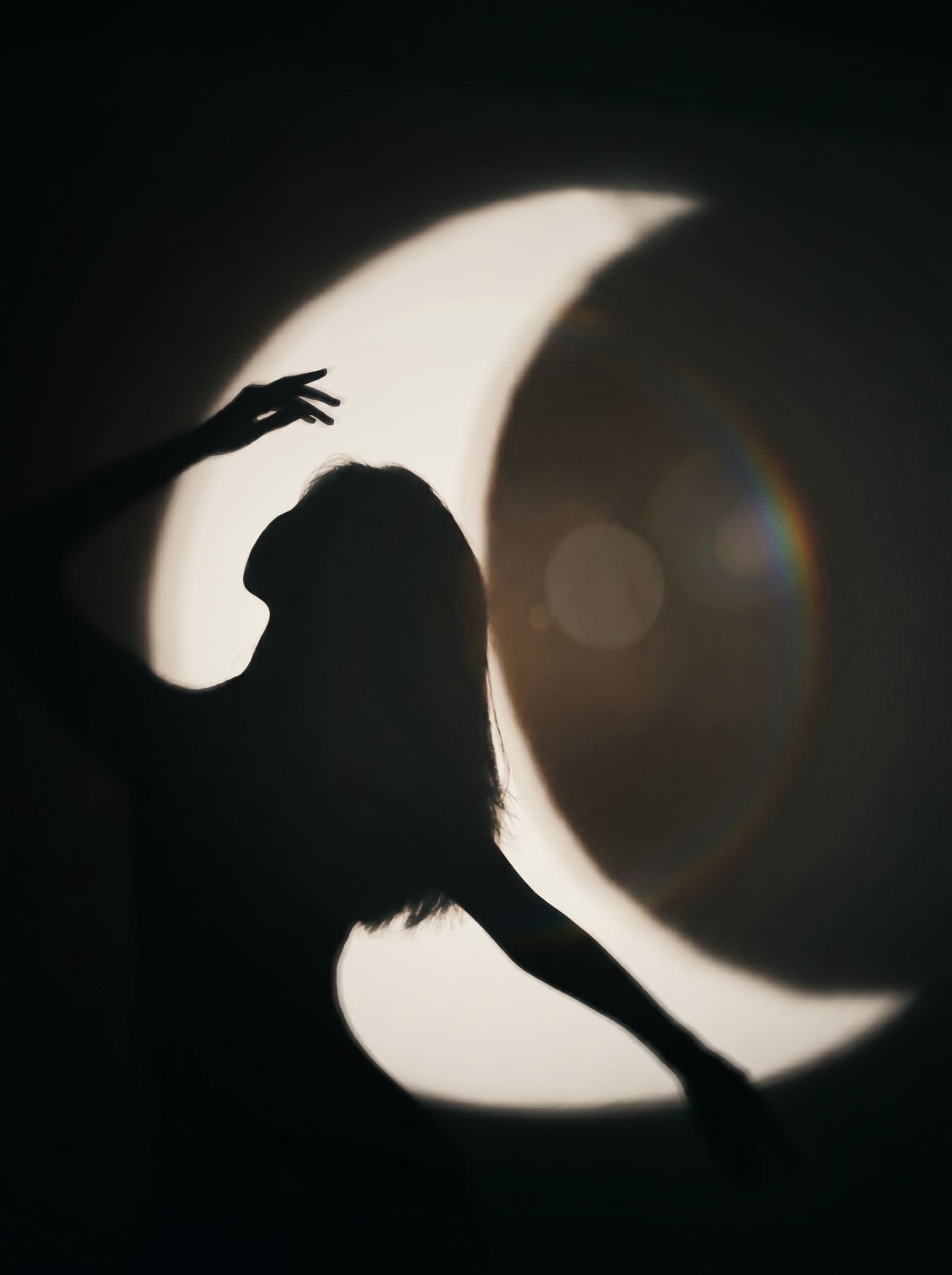 Dancer's silhouette before a crescent moon